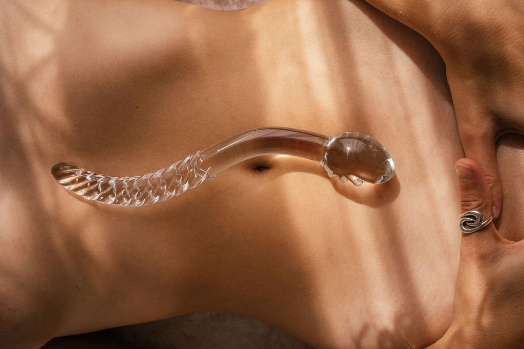 Clear cervix serpent pleasure wand 2.0 pictured on models belly. Glass pleasure wand designed for pelvic dearmouring, massage and self pleasure.